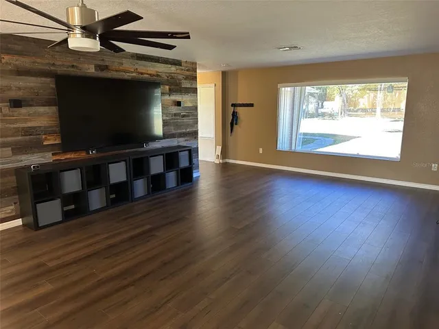 a living room with hardwood floor and a flat screen tv