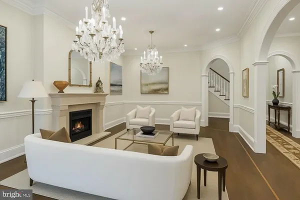 a living room with furniture a fireplace and chandelier