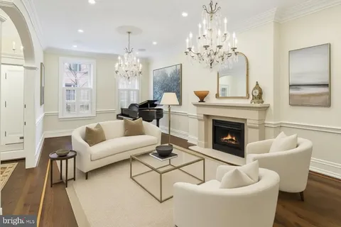 a living room with furniture a chandelier and a fireplace