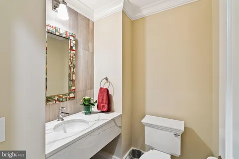 a bathroom with a sink vanity mirror and toilet