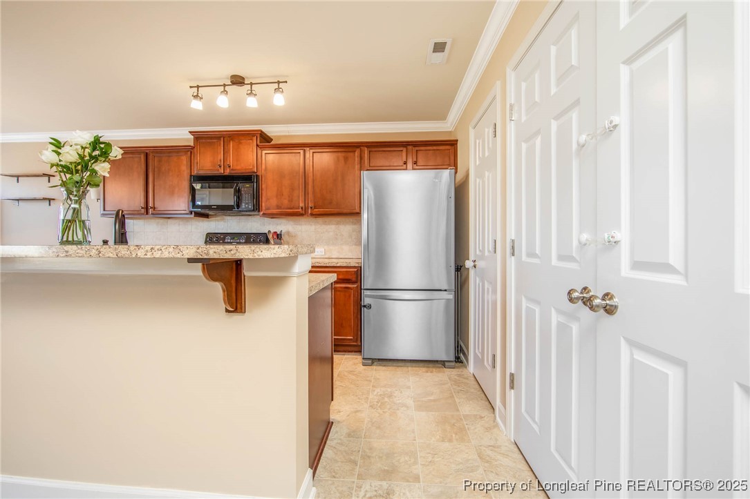 298 Declaration Drive Raeford, NC 28376 - Photo 7 of 31 a kitchen with a refrigerator a stove top oven a sink and a window