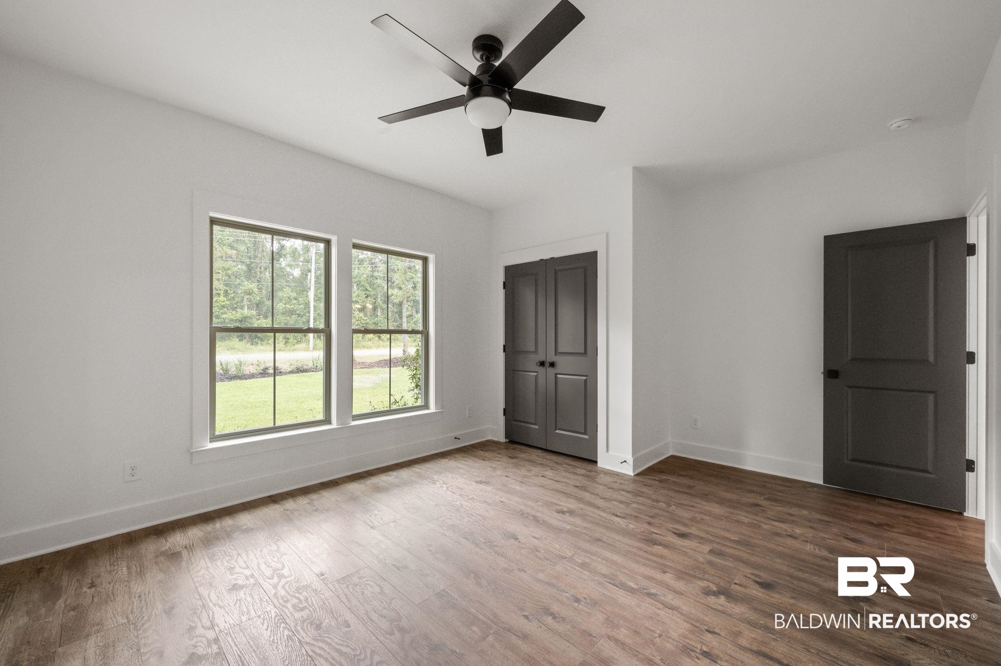 12412 Mannich Lane Foley, AL 36535 - Photo 18 of 23 Unfurnished bedroom with ceiling fan, a closet, and hardwood / wood-style floors
