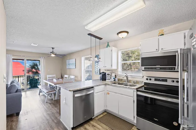 a kitchen with stainless steel appliances granite countertop a sink refrigerator and microwave