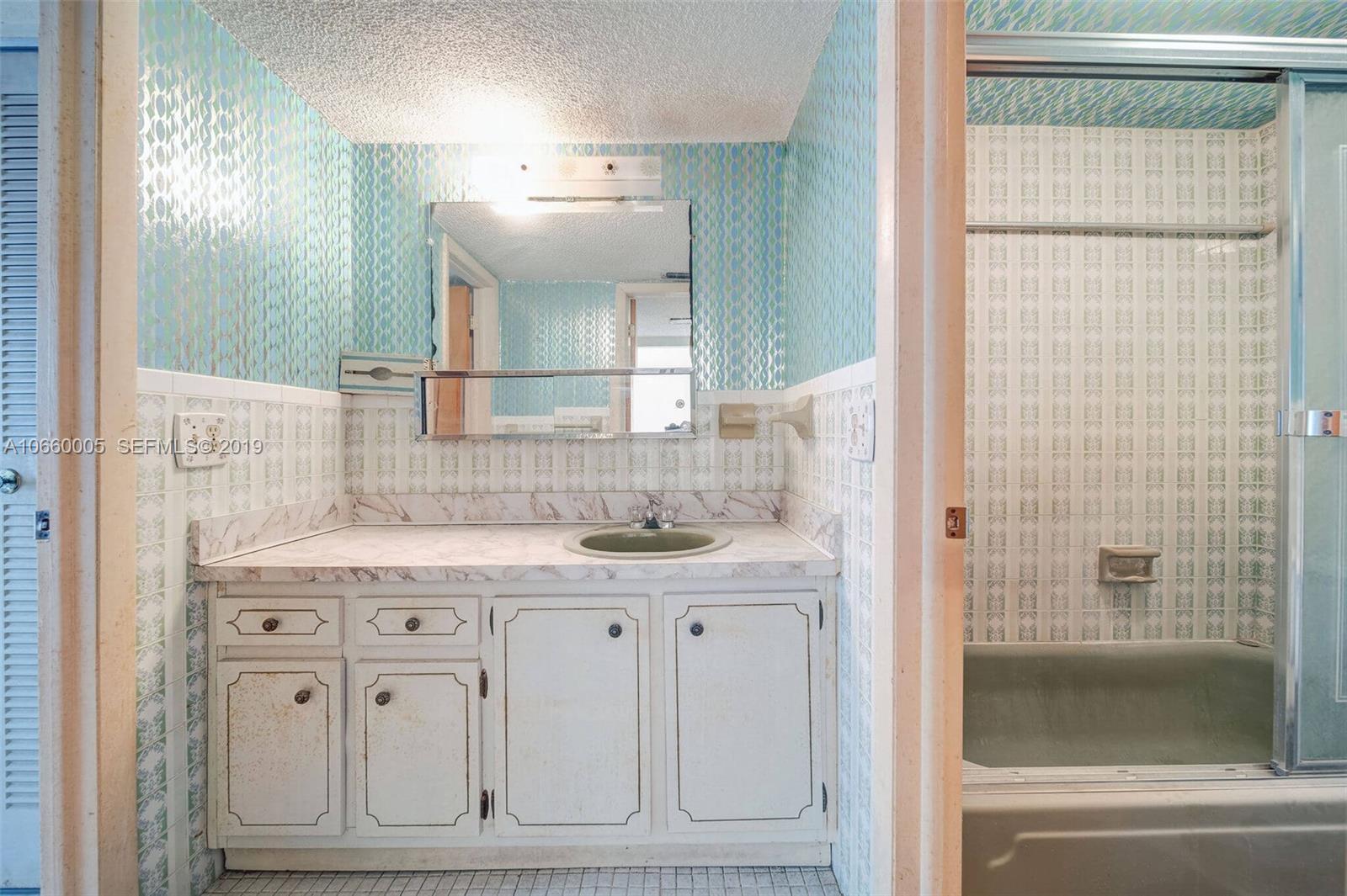 1674 Bay Road, Unit 403 Miami Beach, FL 33139 - Photo 22 of 23 a bathroom with a double vanity sink mirror and shower