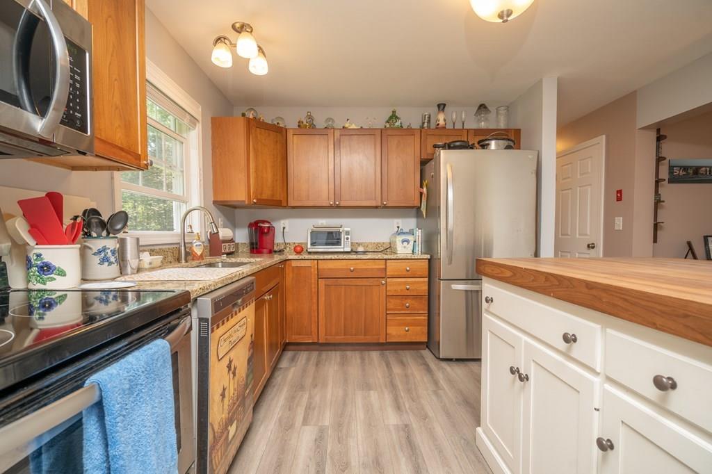 79 Breakneck Road Sturbridge, MA 01566 - Photo 8 of 25 a kitchen with stainless steel appliances granite countertop a stove a sink dishwasher and a refrigerator with wooden cabinets