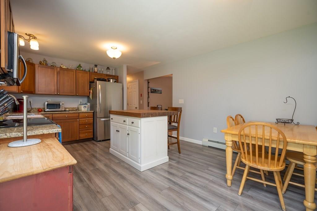 79 Breakneck Road Sturbridge, MA 01566 - Photo 10 of 25 a kitchen with a table chairs refrigerator and microwave