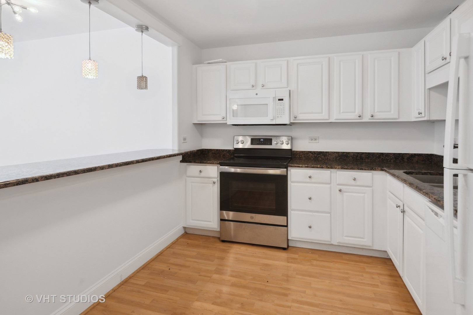 211 East Ohio Street, Unit 609 Chicago, IL 60611 - Photo 5 of 19 a kitchen with granite countertop white cabinets and white appliances