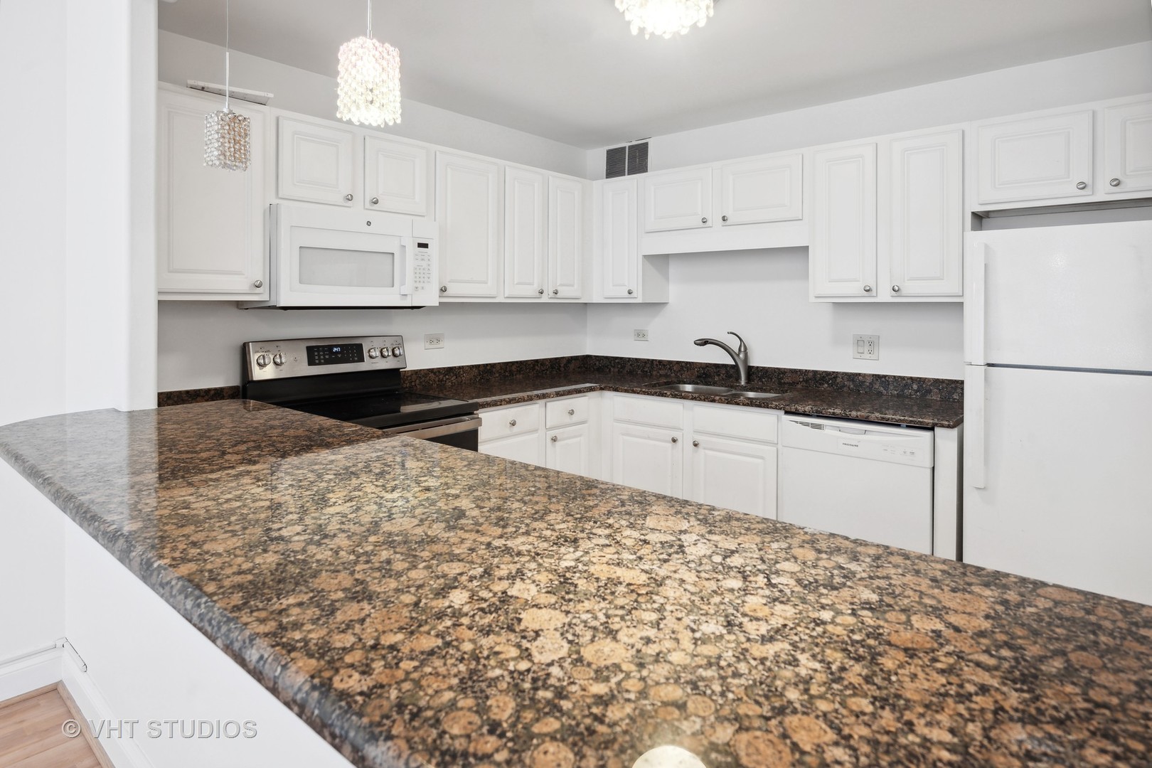 211 East Ohio Street, Unit 609 Chicago, IL 60611 - Photo 6 of 19 a kitchen with granite countertop a sink and white cabinets
