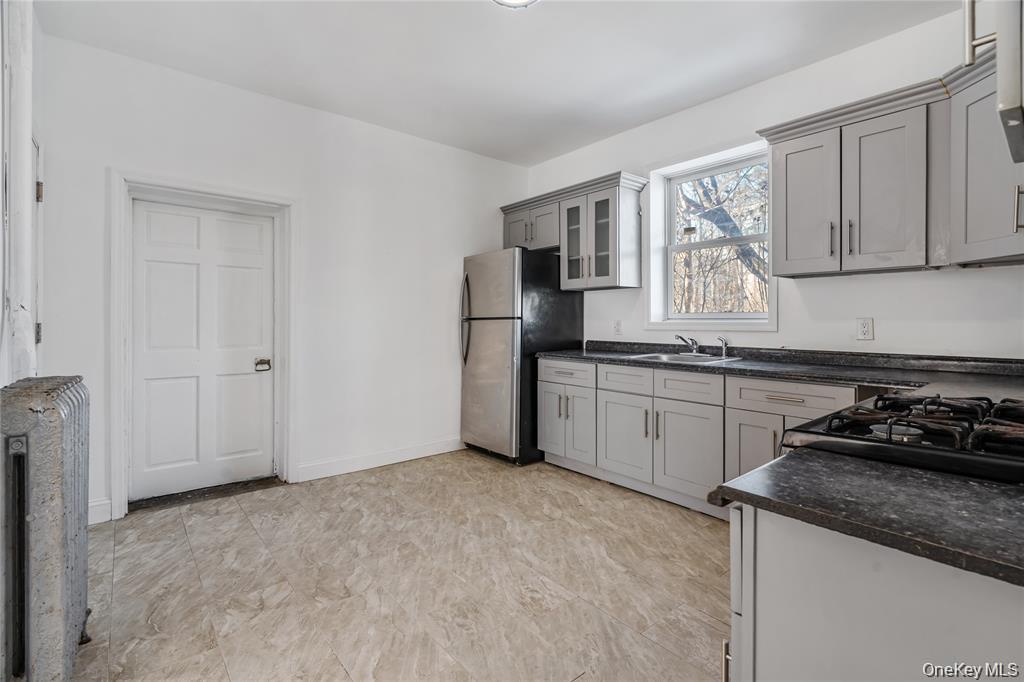94 Winnikee Avenue, Unit 3 Poughkeepsie, NY 12601 - Photo 3 of 12 a kitchen with a stove a sink and a refrigerator