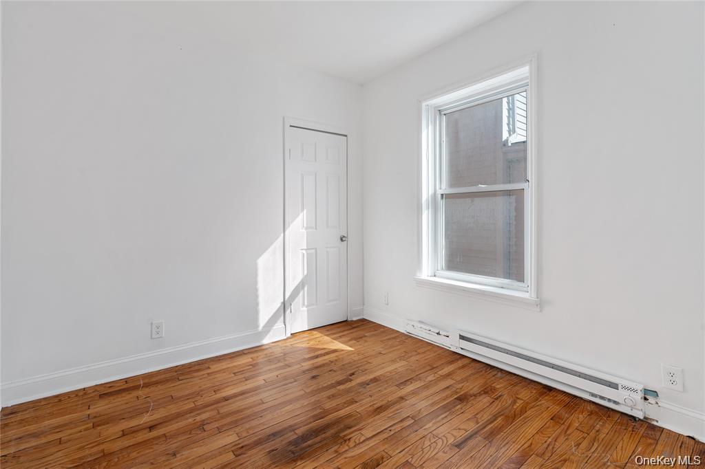 94 Winnikee Avenue, Unit 3 Poughkeepsie, NY 12601 - Photo 8 of 12 an empty room with wooden floor and windows