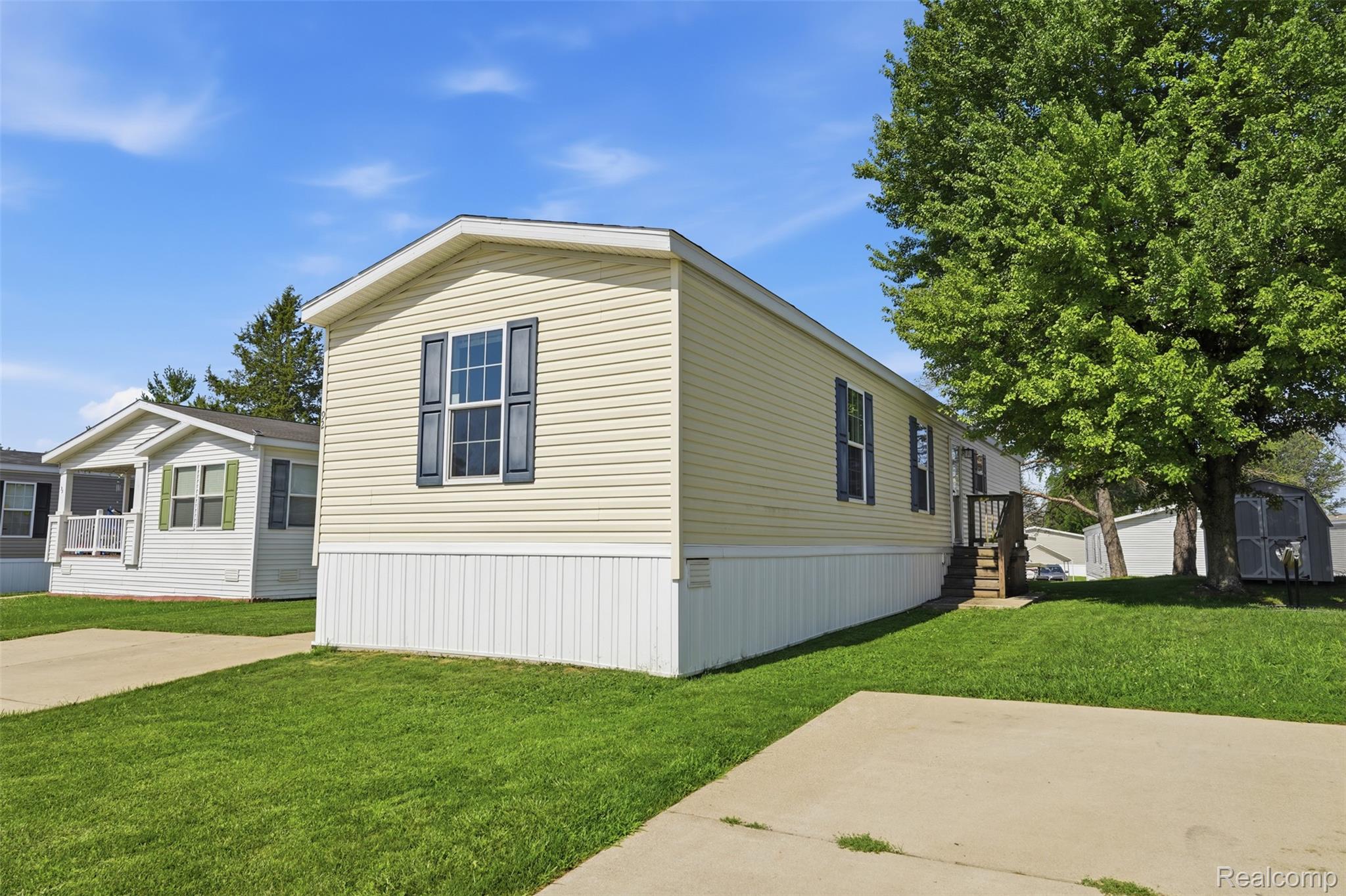 92 Normandy Drive Howell, MI 48843 - Photo 18 of 24 Light-toned siding exterior with dark shutters, white trim, and a white skirting foundation