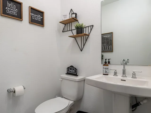 a bathroom with a toilet a sink and mirror