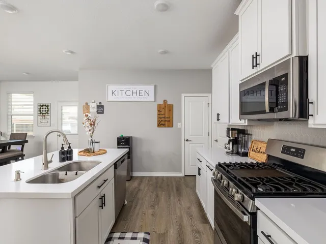 a kitchen with stainless steel appliances a sink stove top oven and cabinets