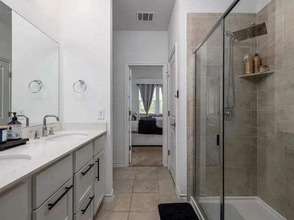 a en suite bathroom with a granite countertop sink and a mirror