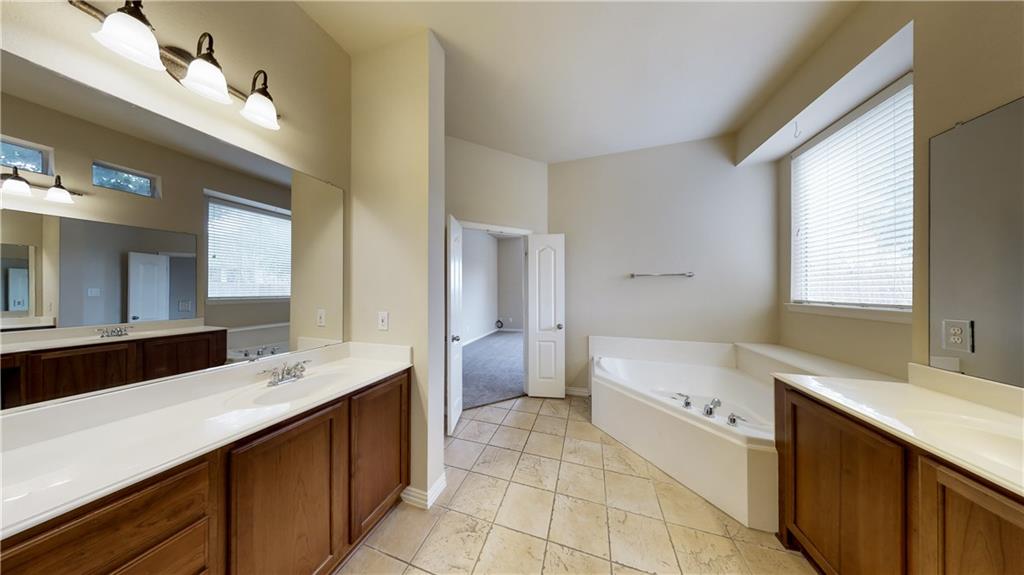 7136 Playa Grand Prairie, TX 75054 - Photo 32 of 36 a bathroom with a double vanity sink a mirror and a bathtub