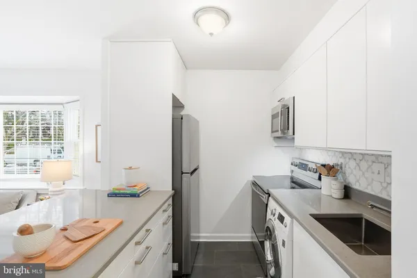 a kitchen that has a sink and a stove in it