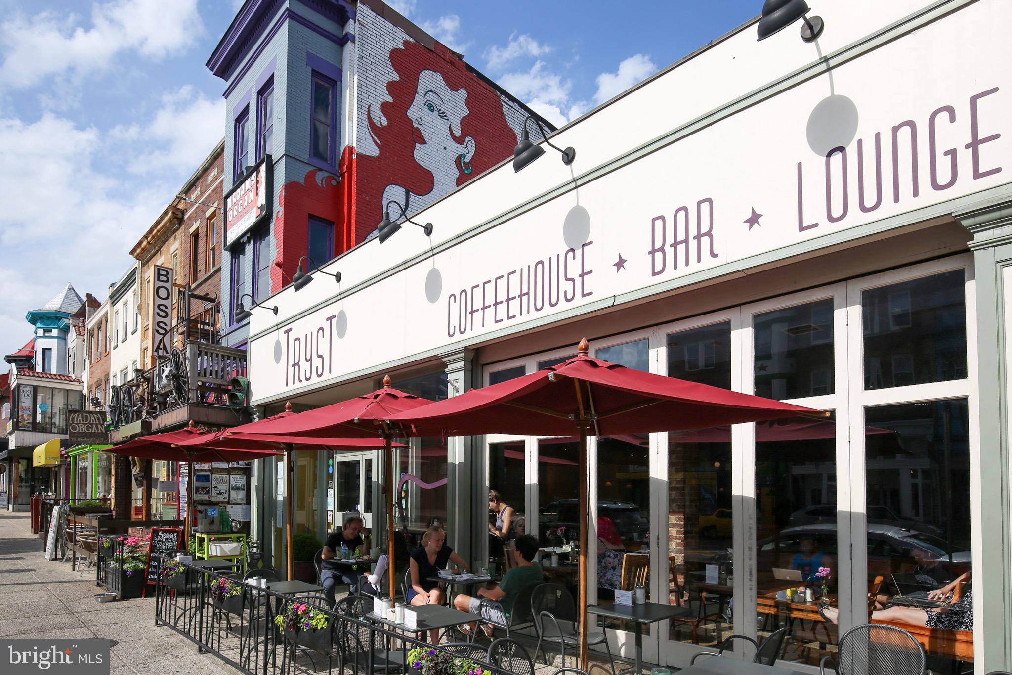 1833-1855 Biltmore Street Northwest, Unit A Washington, DC 20009 - Photo 21 of 22 a view of a cafe with a table and chairs under an umbrella