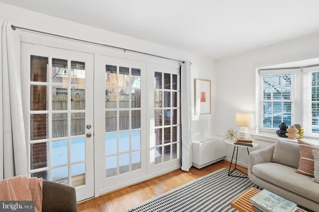 a living room with furniture a lamp and windows