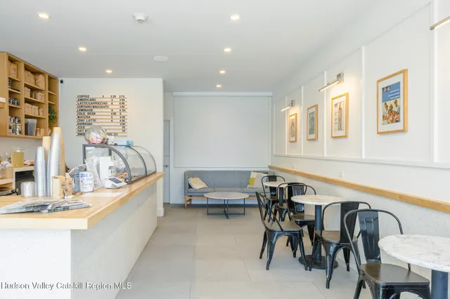 a dining room with furniture and a floor to ceiling window