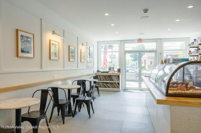 a dining room with furniture and a floor to ceiling window