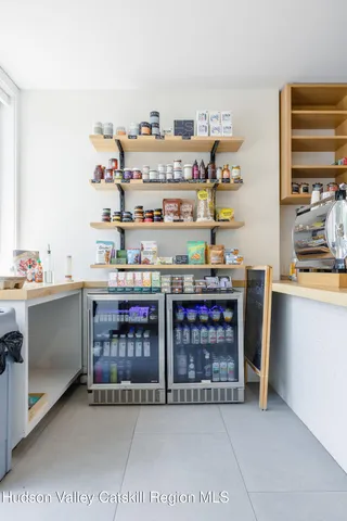 a room with stainless steel appliances a sink and a book shelf
