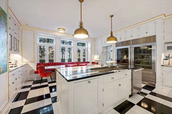 a kitchen with stainless steel appliances granite countertop a sink and a dining table view