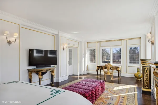 a bedroom with a bed and dresser with mirror