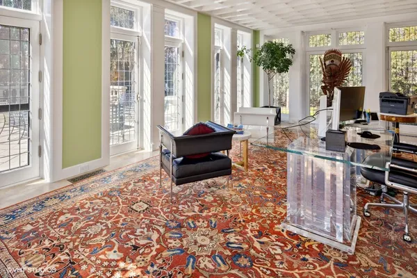 a view of a dining room and livingroom with furniture wooden floor a chandelier