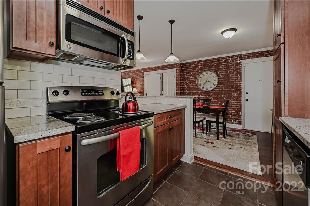 4919 Park Road, Unit D Charlotte, NC 28209 - Photo 11 of 27 a kitchen with stainless steel appliances granite countertop a stove and a microwave