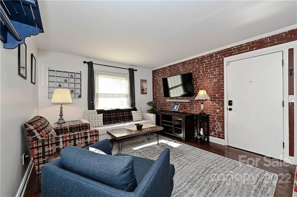 4919 Park Road, Unit D Charlotte, NC 28209 - Photo 14 of 27 a living room with furniture a fireplace and a flat screen tv