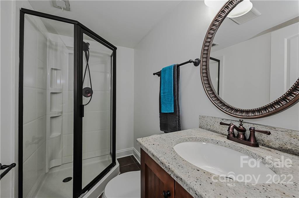 4919 Park Road, Unit D Charlotte, NC 28209 - Photo 19 of 27 a bathroom with a granite countertop sink a mirror and a shower