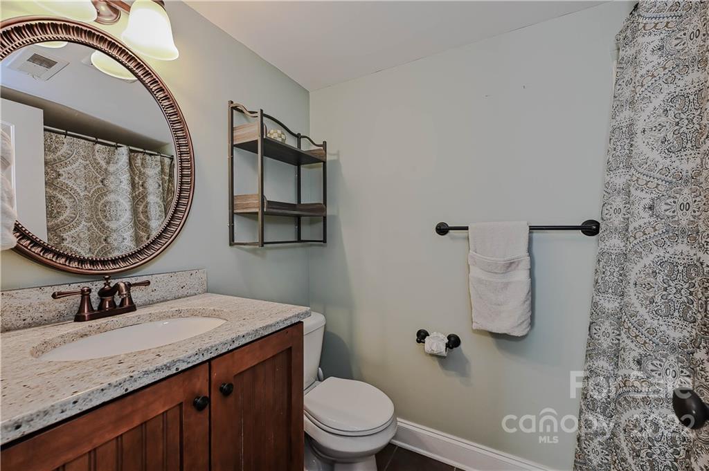 4919 Park Road, Unit D Charlotte, NC 28209 - Photo 21 of 27 a bathroom with a granite countertop toilet sink and mirror