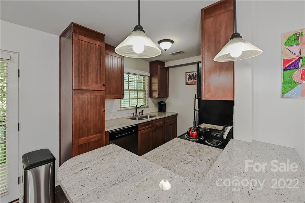 4919 Park Road, Unit D Charlotte, NC 28209 - Photo 8 of 27 a kitchen with stainless steel appliances granite countertop a sink dishwasher a stove and a refrigerator with wooden floor