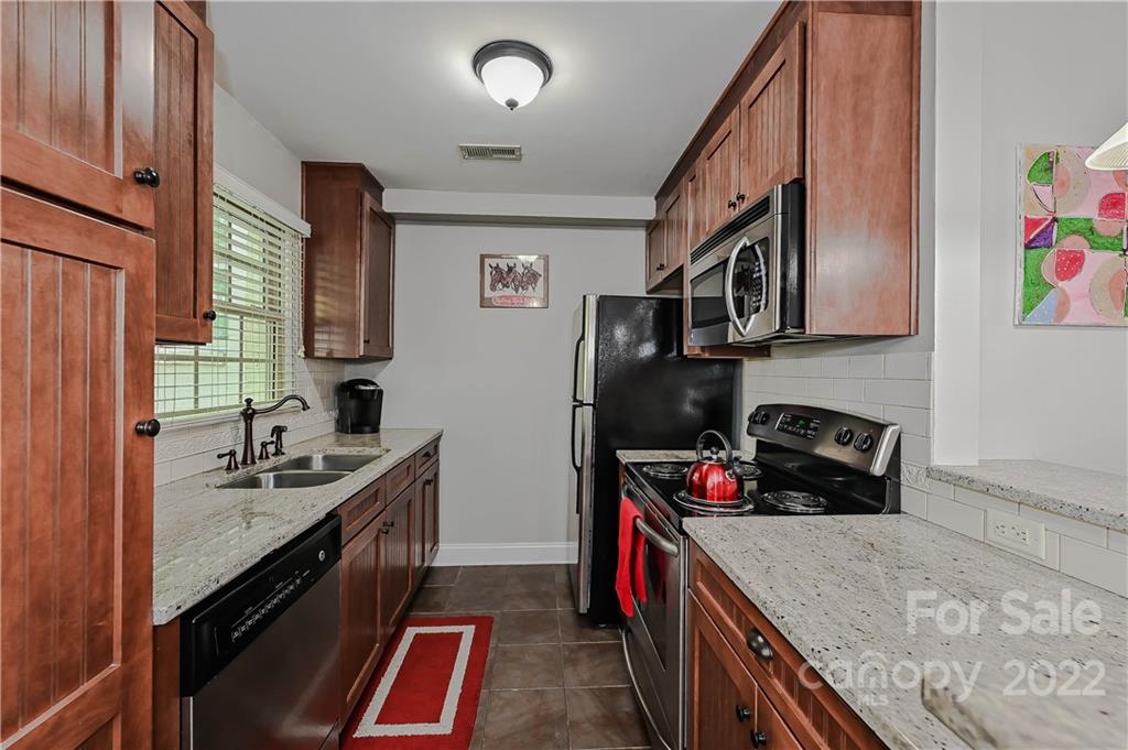 4919 Park Road, Unit D Charlotte, NC 28209 - Photo 9 of 27 a kitchen with stainless steel appliances granite countertop a sink stove and cabinets