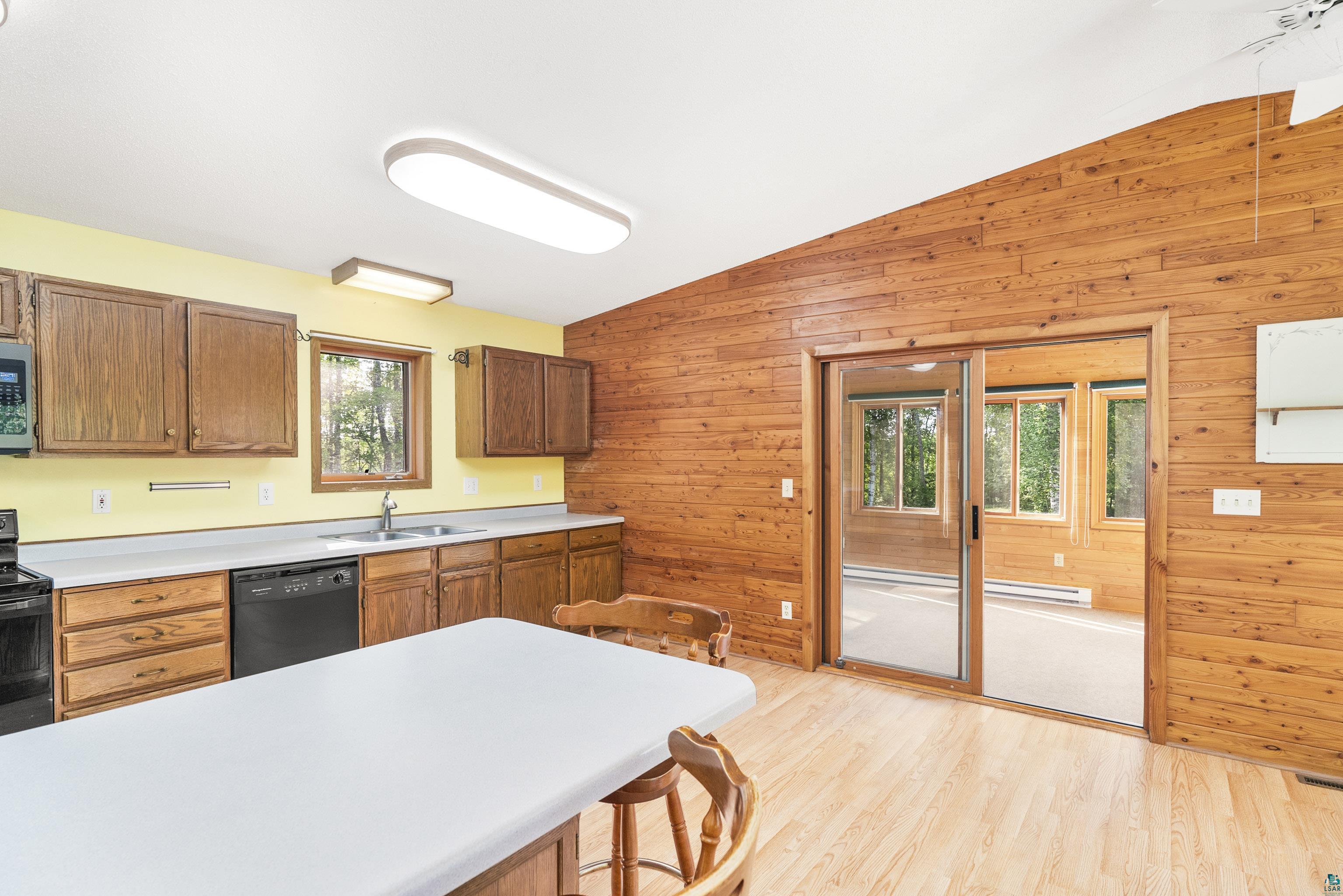 5410 Lavaque Road Duluth, MN 55803 - Photo 17 of 48 Kitchen with wood walls, light wood-type flooring, black appliances, and vaulted ceiling