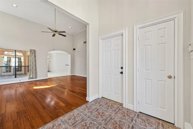 a view of a livingroom with a flat screen tv wooden floor and a ceiling fan