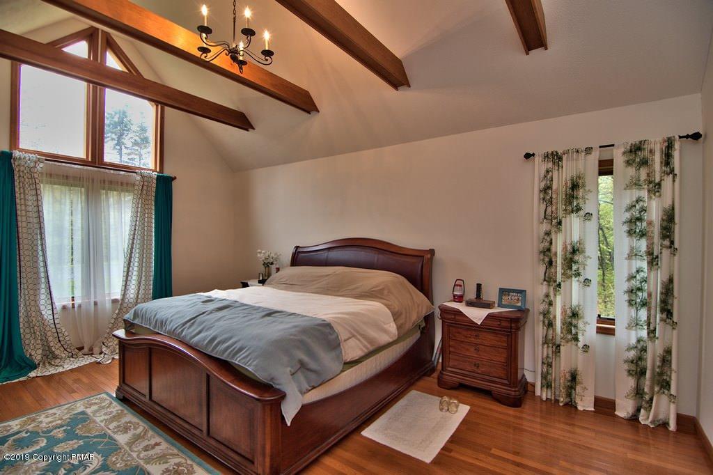 4160 Hickory Road Tobyhanna, PA 18466 - Photo 31 of 45 a bed sitting in a bedroom next to a window and a chandelier