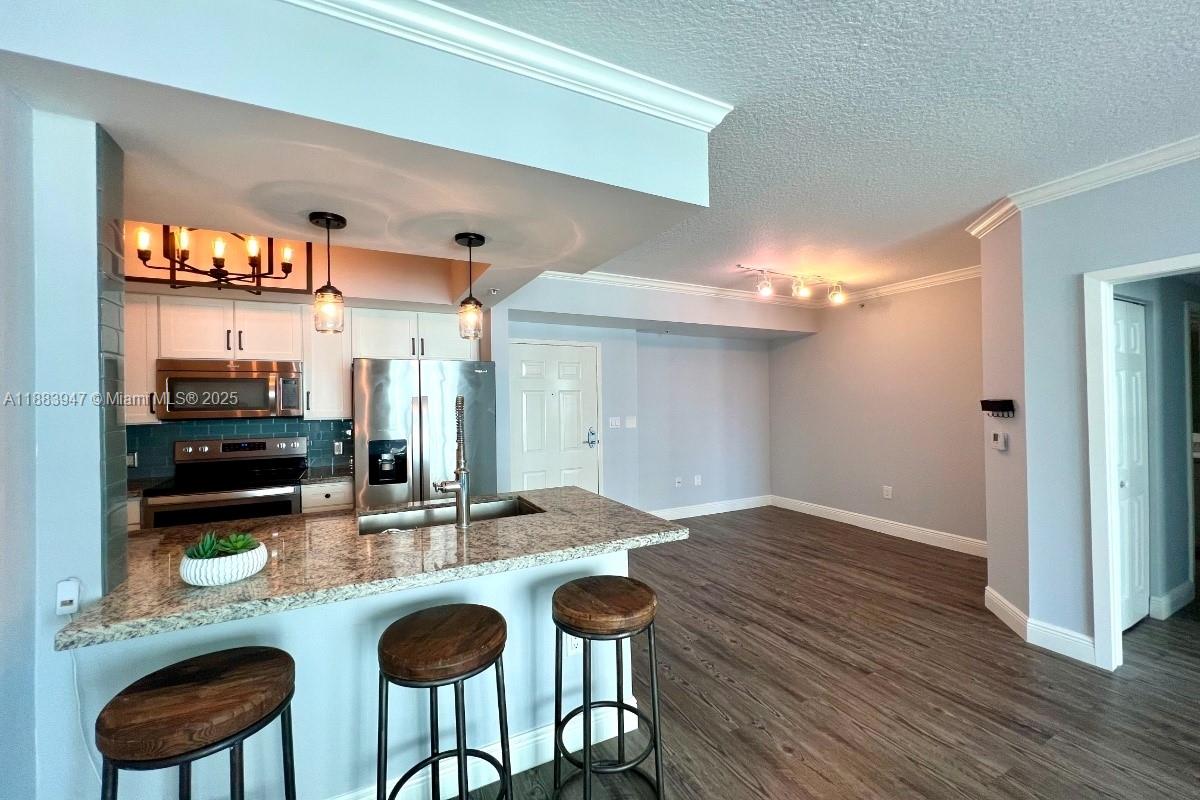 2000 North Bayshore Drive, Unit 1105 Miami, FL 33137 - Photo 12 of 29 a kitchen with stainless steel appliances granite countertop a table and chairs in it