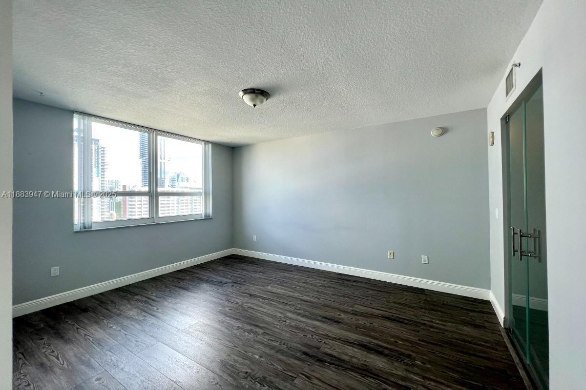 2000 North Bayshore Drive, Unit 1105 Miami, FL 33137 - Photo 15 of 29 a view of an empty room with wooden floor and a window