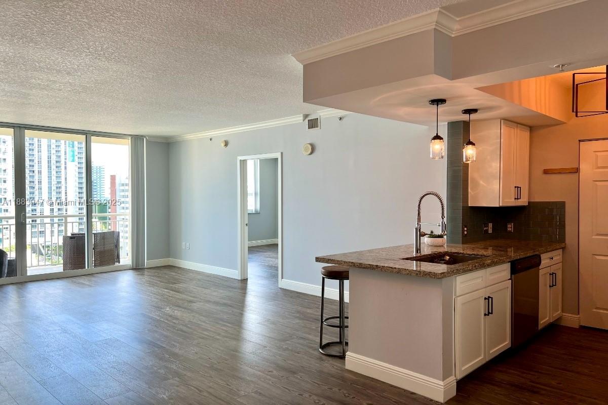 2000 North Bayshore Drive, Unit 1105 Miami, FL 33137 - Photo 6 of 29 a kitchen with stainless steel appliances granite countertop a sink cabinets and wooden floor