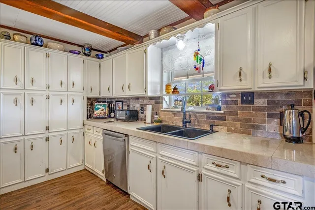 a kitchen with lot of cabinets a sink and appliances