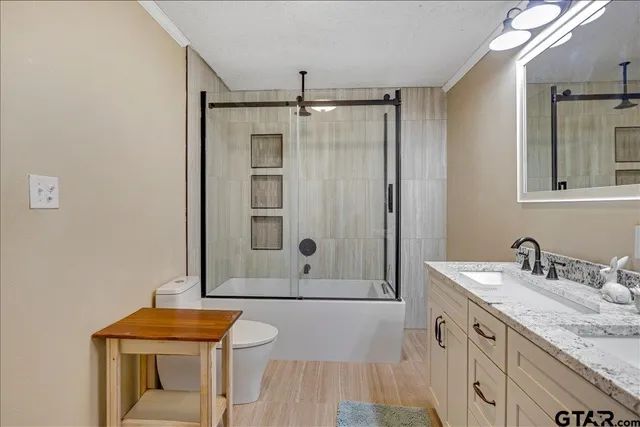 a bathroom with a granite countertop sink a mirror and shower