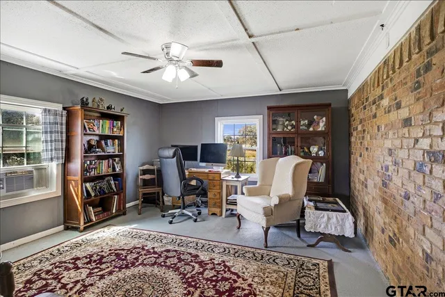 a view of a livingroom with workspace and a window