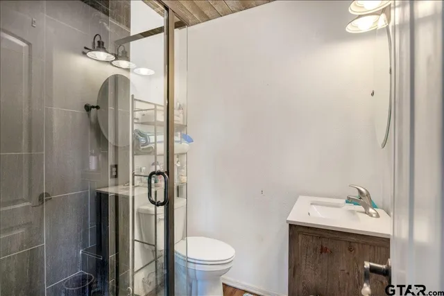 a bathroom with a granite countertop sink toilet and shower