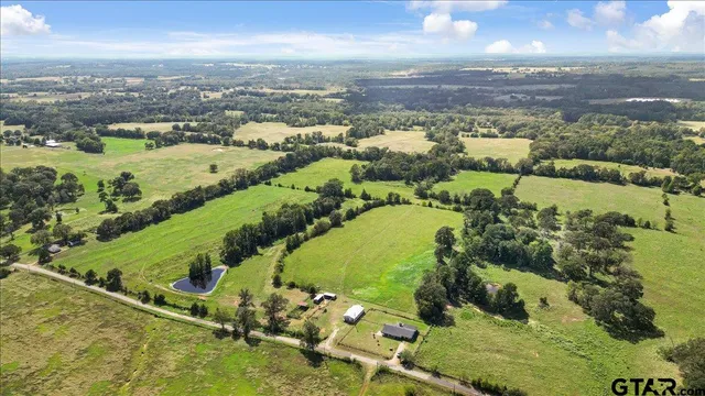 an aerial view of ocean and residential houses with outdoor space