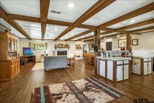 a living room with stainless steel appliances granite countertop lots of counter space and a couch