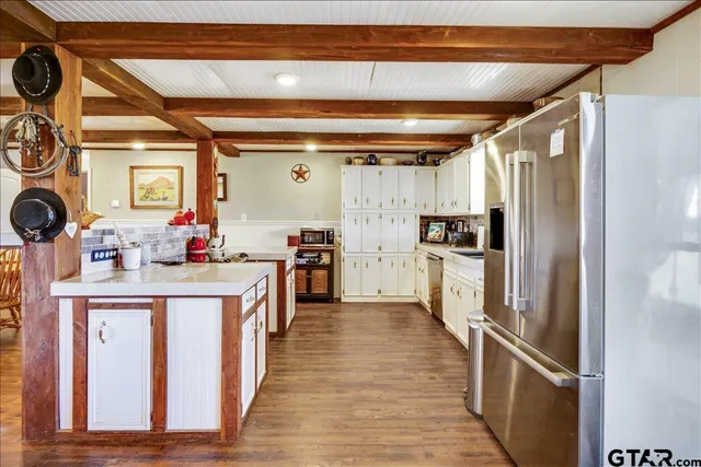 a kitchen with kitchen island a counter top space a sink appliances and cabinets