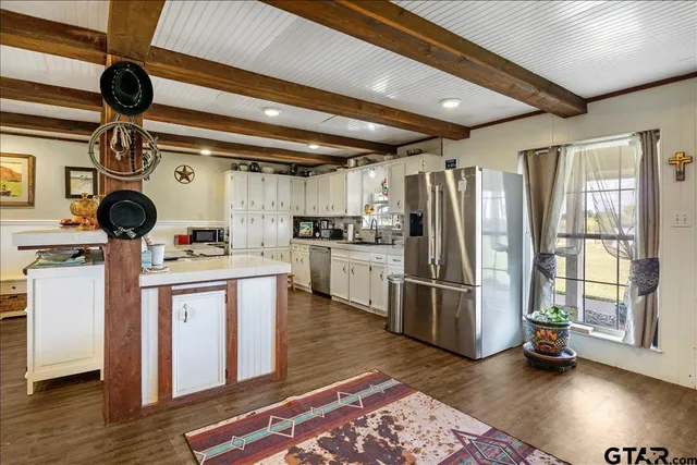 a kitchen with stove a refrigerator and wooden floor