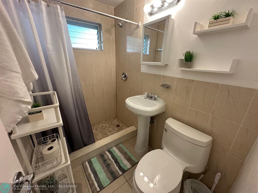 1605 Southwest 25th Street, Unit 4 Fort Lauderdale, FL 33315 - Photo 12 of 14 a white toilet sitting next to a bathroom sink