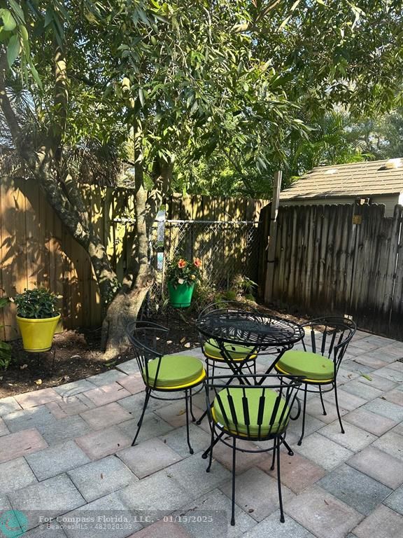 1605 Southwest 25th Street, Unit 4 Fort Lauderdale, FL 33315 - Photo 14 of 14 a backyard of a house with table and chairs